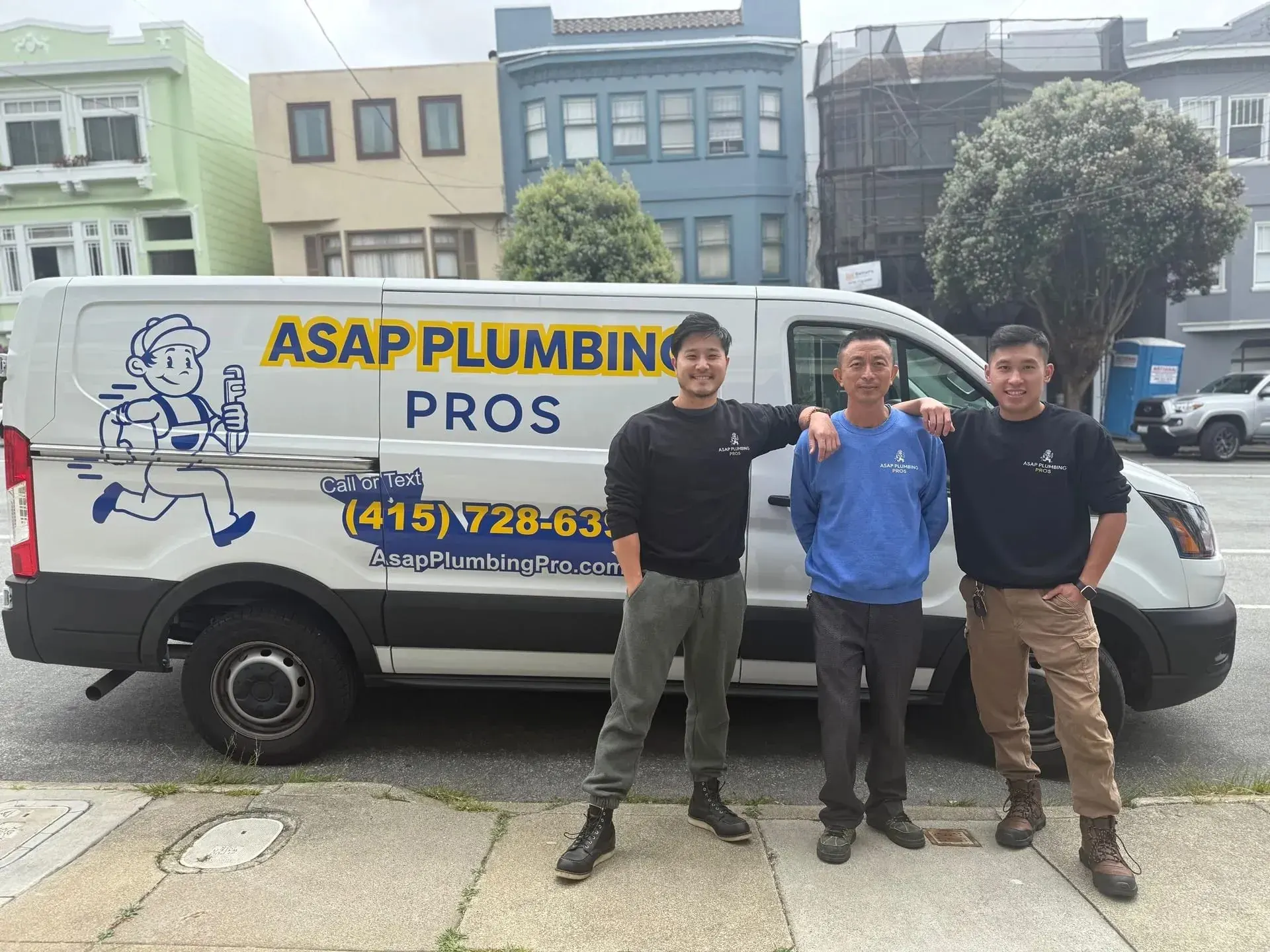Three plumbers standing in front of ASAP Plumbing Pros service van on city street